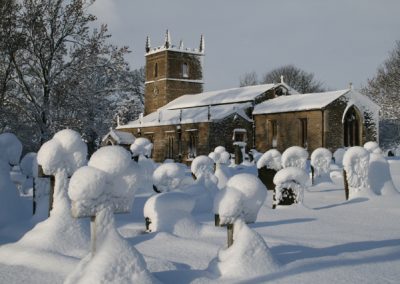 A view of the church and churchyard covered in snow